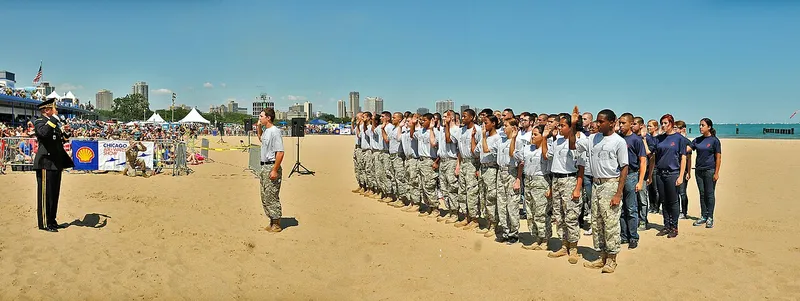 A U.S. Army general administers the oath of enlistment to a group of recruits from several military branches on a Chicago beach during an air show